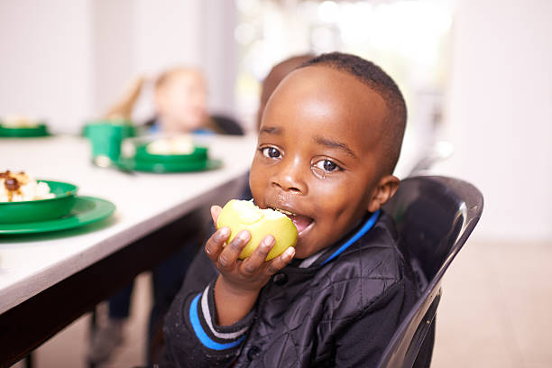 Enfant à table pendant le repas de cantine